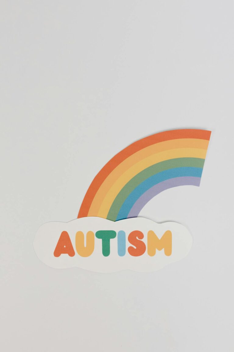 Colorful autism awareness design featuring a rainbow and cloud on a white background.